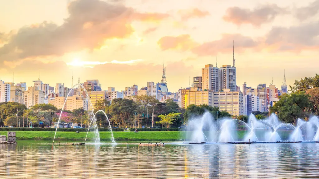 Parque Ibirapuera ao entardecer com o skyline de São Paulo ao fundo