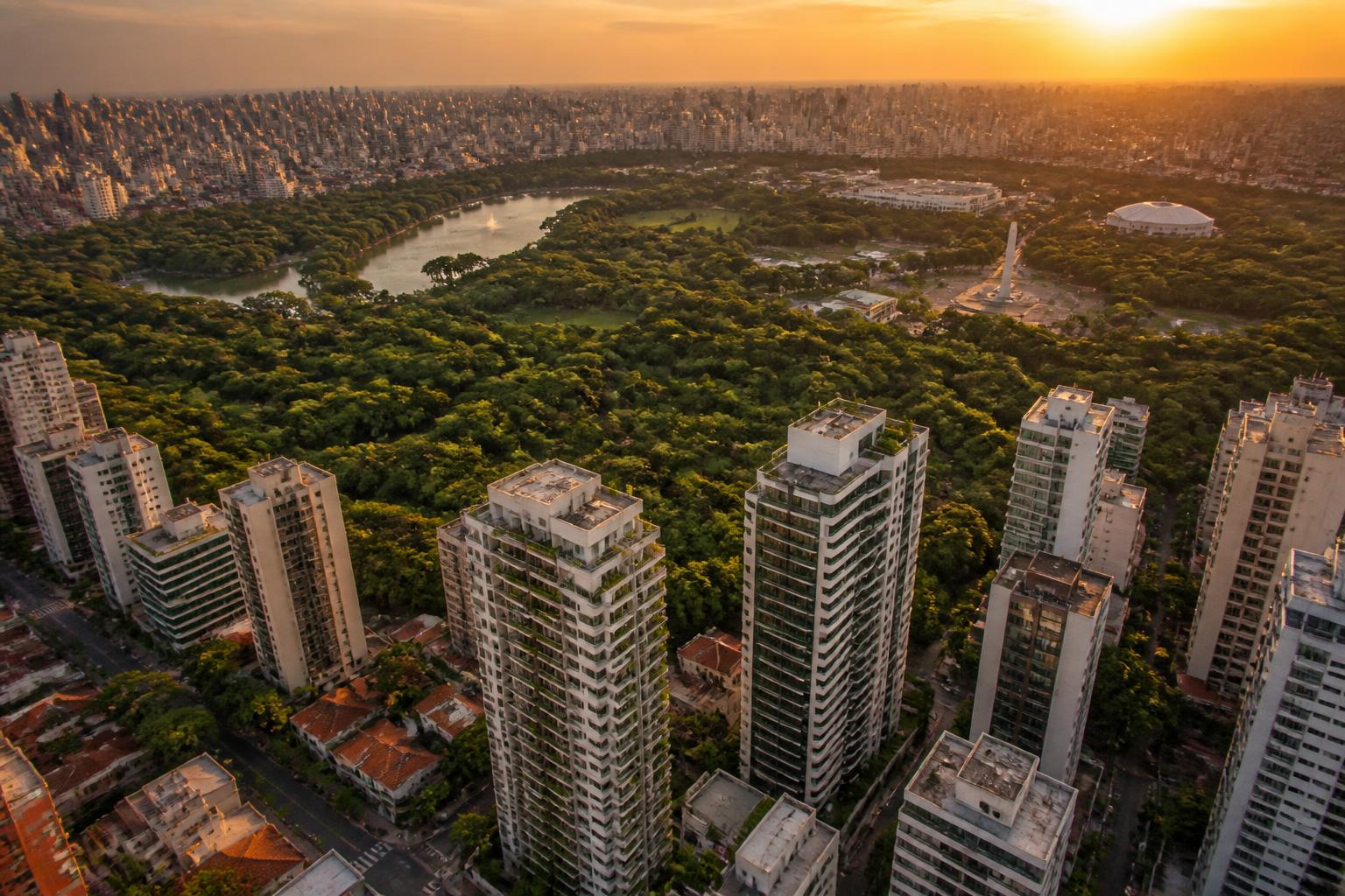 Vista aérea do Parque Ibirapuera ao entardecer com torres residenciais ao redor